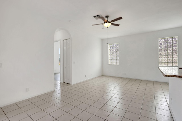 tiled spare room featuring ceiling fan