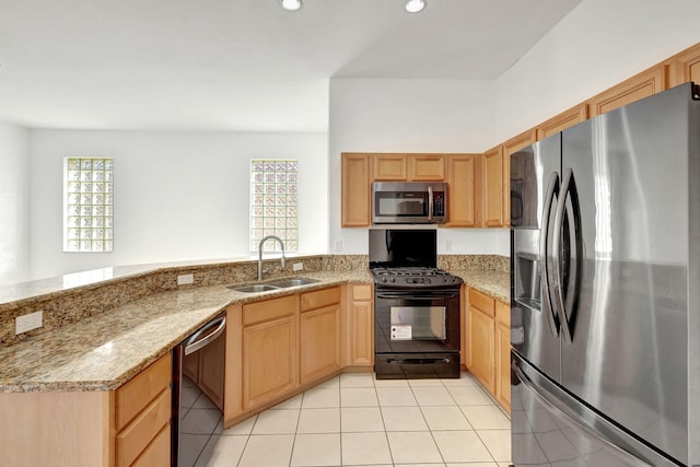 kitchen featuring a healthy amount of sunlight, sink, light stone countertops, and stainless steel appliances