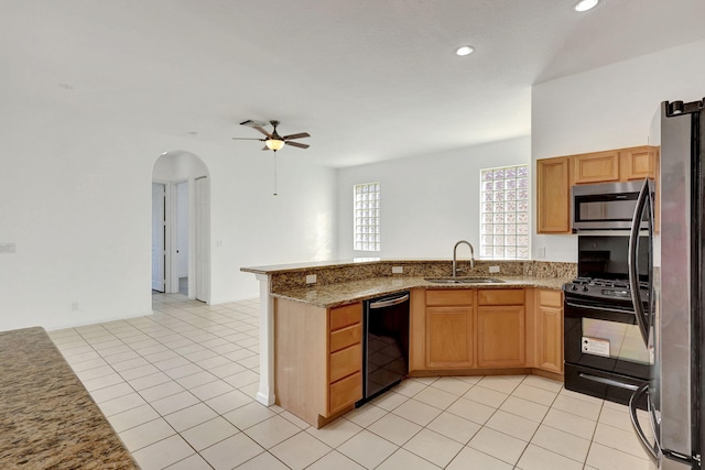 kitchen with black appliances, sink, ceiling fan, stone countertops, and kitchen peninsula