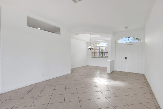 entryway with light tile patterned floors and a chandelier