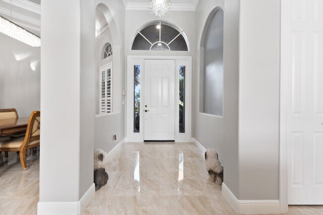 foyer featuring a notable chandelier and ornamental molding