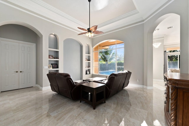 living room featuring ornamental molding, built in features, ceiling fan, and a healthy amount of sunlight