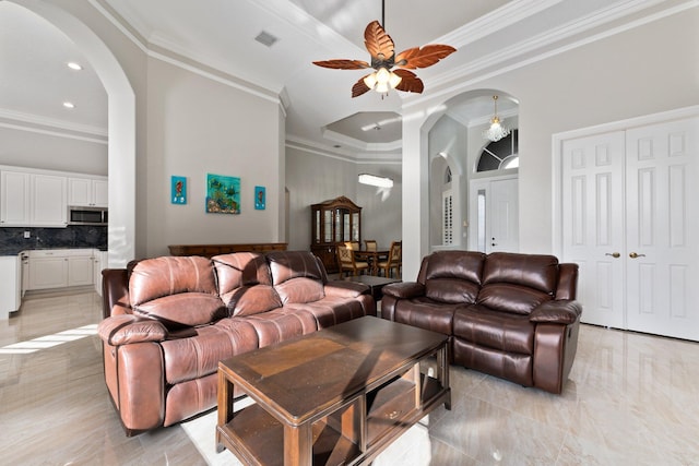 living room featuring a tray ceiling, ceiling fan, and ornamental molding