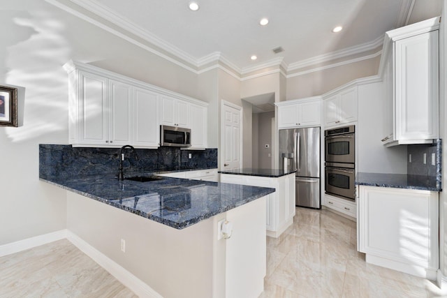 kitchen featuring white cabinetry, sink, stainless steel appliances, kitchen peninsula, and dark stone countertops