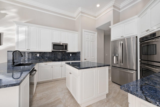 kitchen featuring white cabinets, sink, dark stone countertops, appliances with stainless steel finishes, and a kitchen island