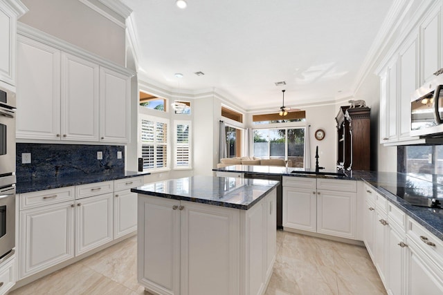 kitchen with white cabinets, kitchen peninsula, and sink