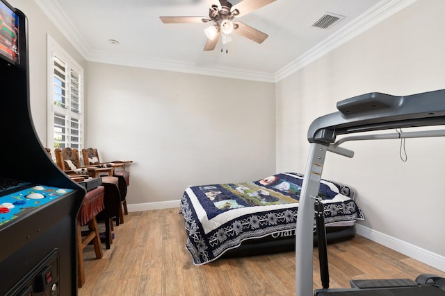 bedroom with hardwood / wood-style flooring, ceiling fan, and crown molding