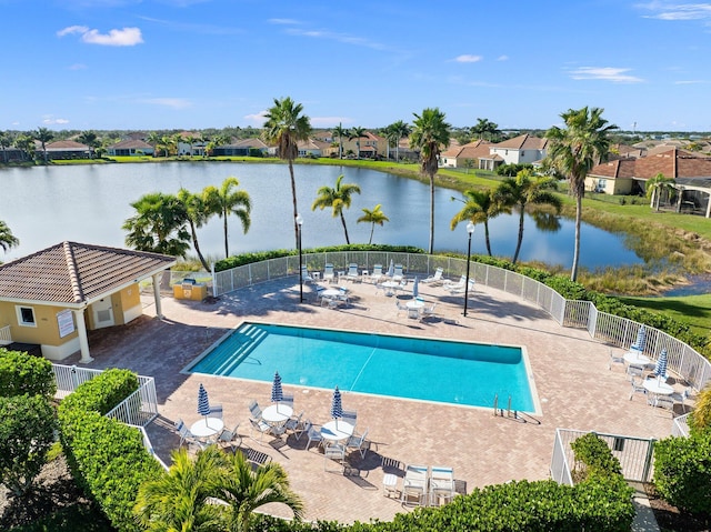 view of swimming pool featuring a water view and a patio area