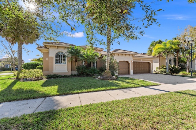 mediterranean / spanish home featuring a front yard and a garage