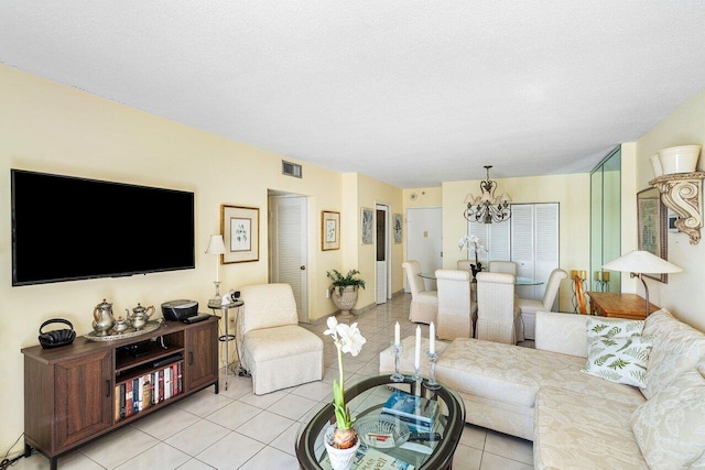 living room with light tile patterned floors, a chandelier, and a textured ceiling