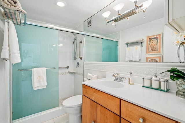 bathroom with tile patterned flooring, vanity, an enclosed shower, and toilet