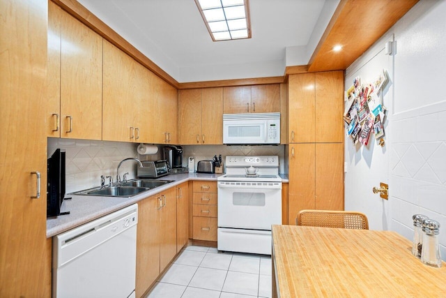 kitchen with light tile patterned flooring, decorative backsplash, white appliances, and sink