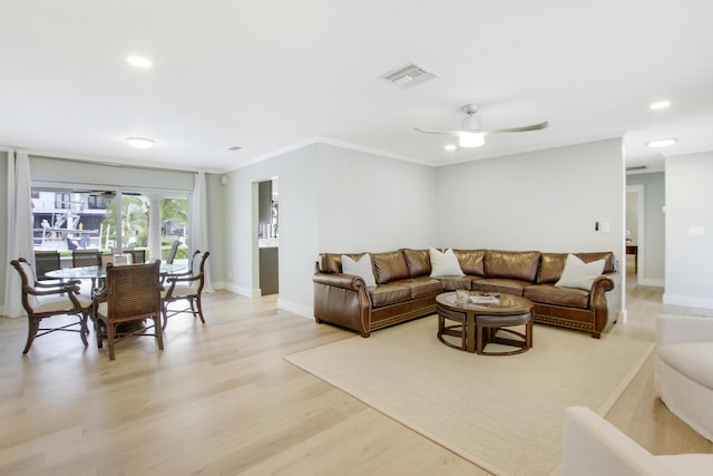 living room featuring light wood-type flooring, ceiling fan, and ornamental molding