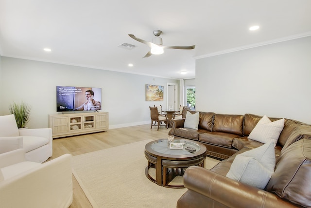 living room featuring light wood-type flooring, ceiling fan, and crown molding