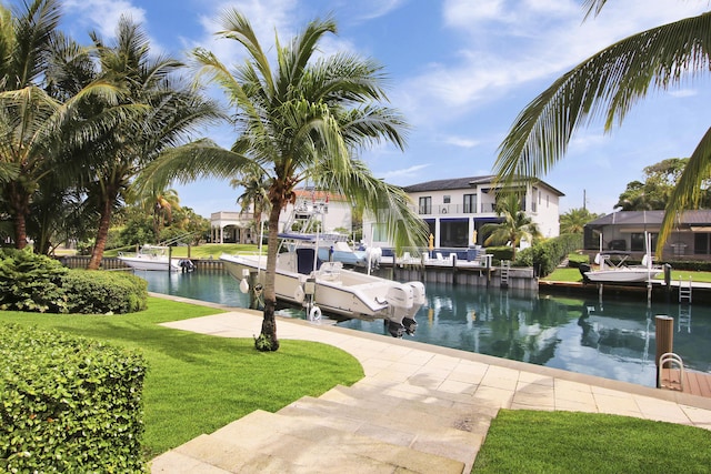 exterior space with a yard, a water view, and a boat dock