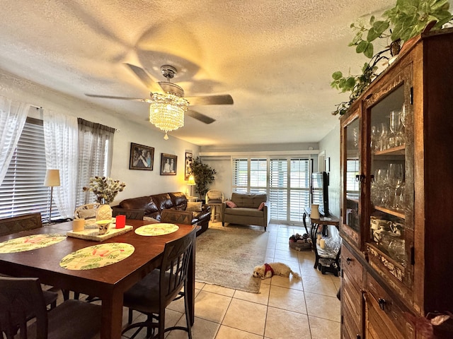 dining room featuring a textured ceiling, ceiling fan, and light tile patterned flooring