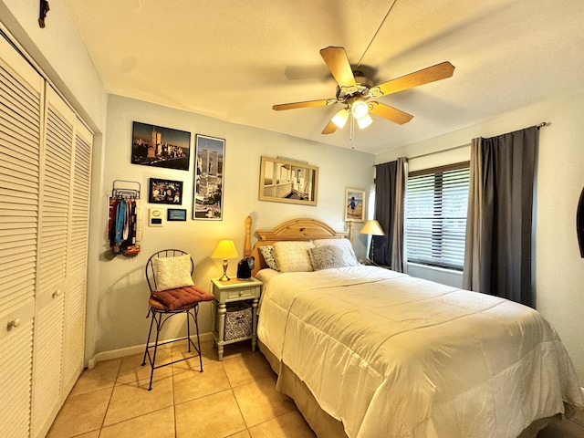 bedroom featuring ceiling fan, a closet, and light tile patterned flooring