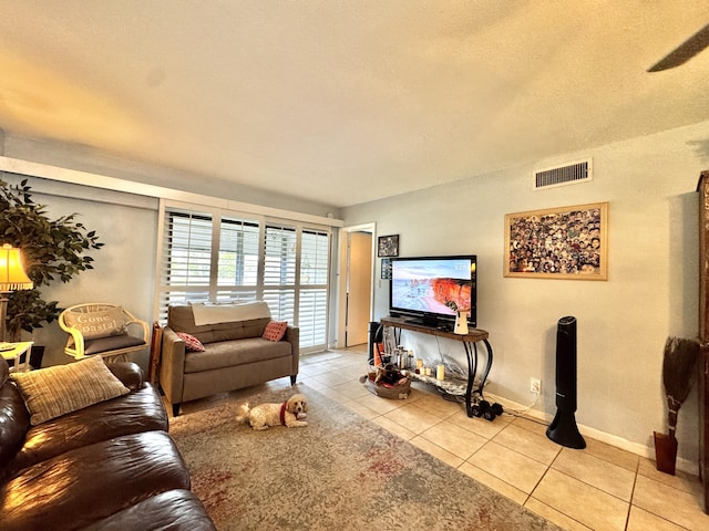 tiled living room with a textured ceiling and ceiling fan