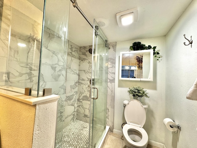 bathroom featuring tile patterned floors, toilet, and a shower with door