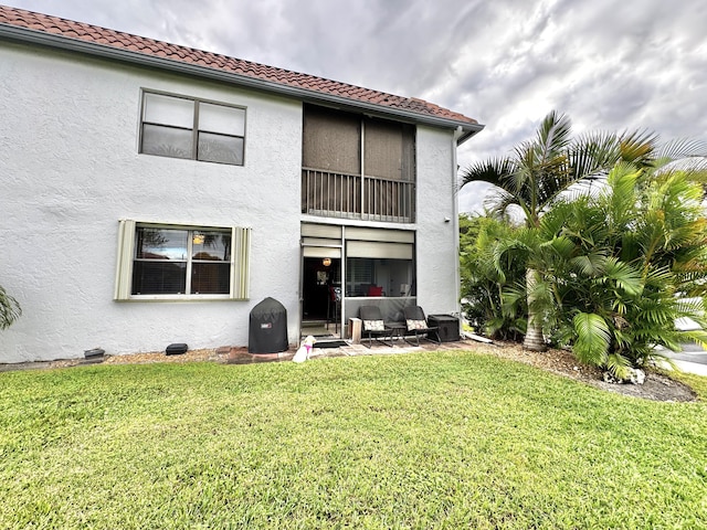 rear view of house featuring a yard