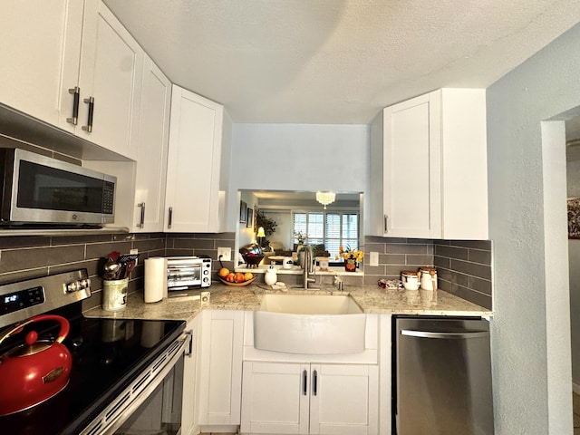 kitchen with white cabinetry, sink, tasteful backsplash, a textured ceiling, and appliances with stainless steel finishes