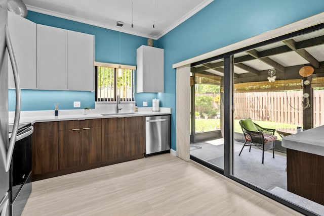 kitchen with sink, decorative light fixtures, dark brown cabinets, white cabinets, and appliances with stainless steel finishes