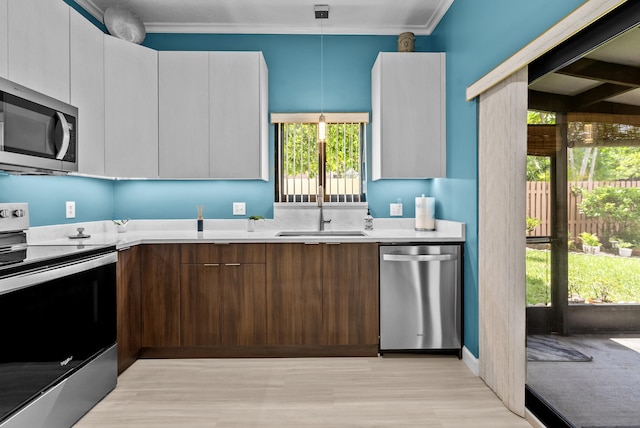 kitchen with pendant lighting, white cabinetry, sink, and appliances with stainless steel finishes