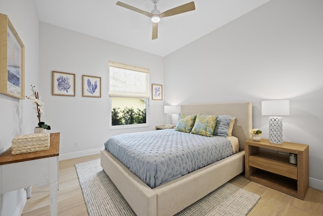 bedroom with ceiling fan, light wood-style flooring, and baseboards