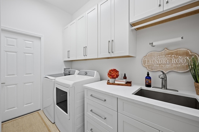 laundry room featuring cabinet space, washer and clothes dryer, and a sink