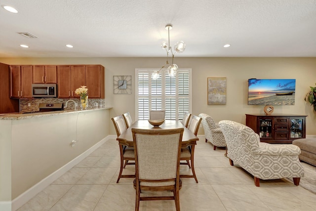 dining area featuring light tile patterned floors, a textured ceiling, and an inviting chandelier