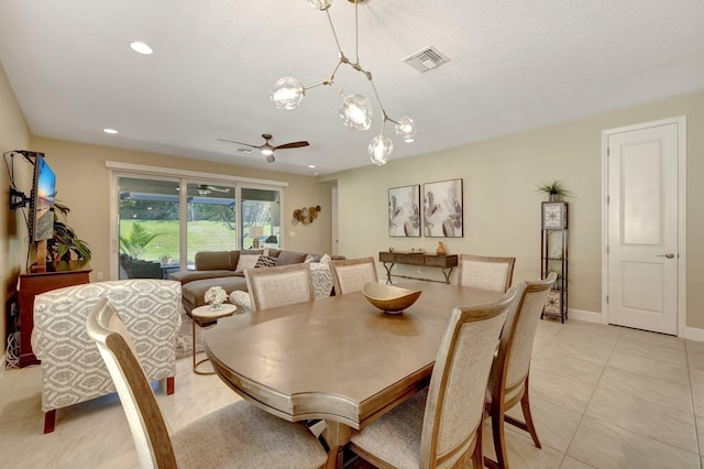 tiled dining area with ceiling fan with notable chandelier