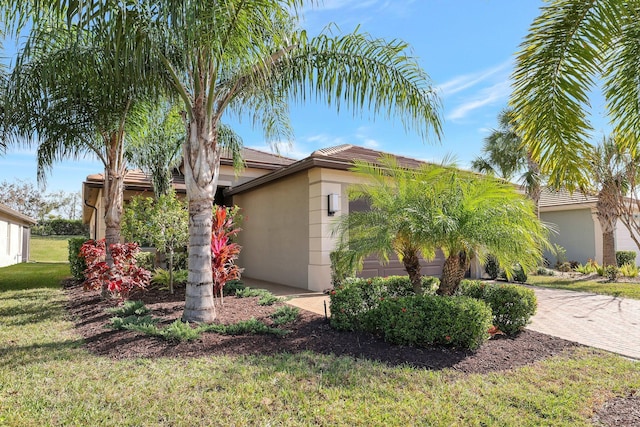 view of side of home with a garage and a lawn