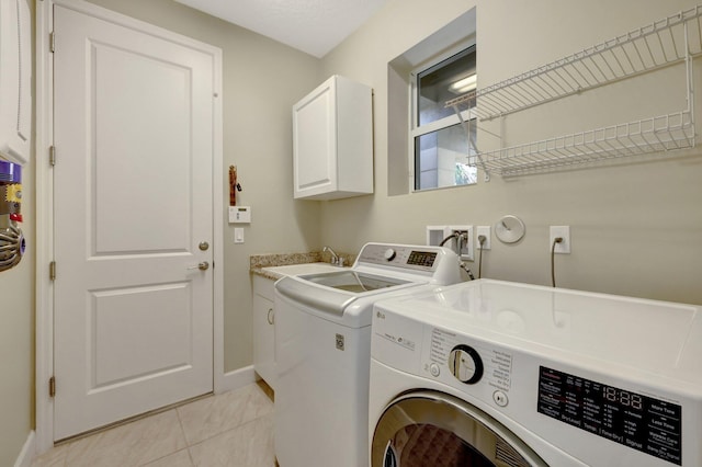 clothes washing area with washer and clothes dryer, cabinets, light tile patterned floors, and sink