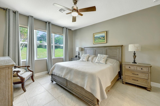 tiled bedroom featuring ceiling fan