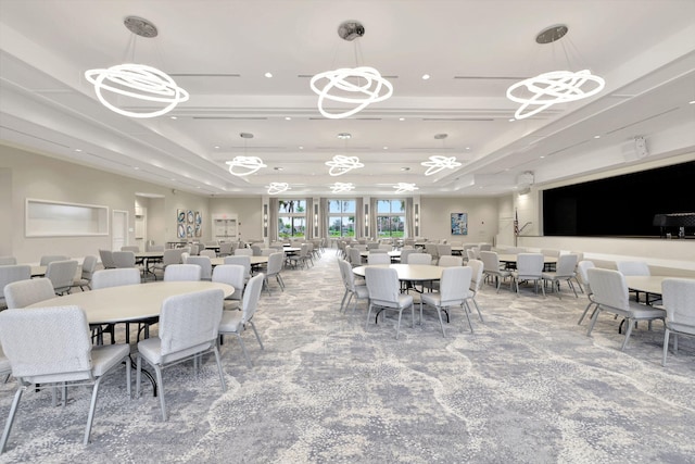 dining room featuring carpet flooring, a raised ceiling, and an inviting chandelier