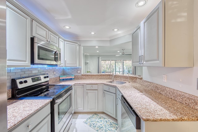 kitchen featuring sink, ceiling fan, light tile patterned floors, ornamental molding, and stainless steel appliances