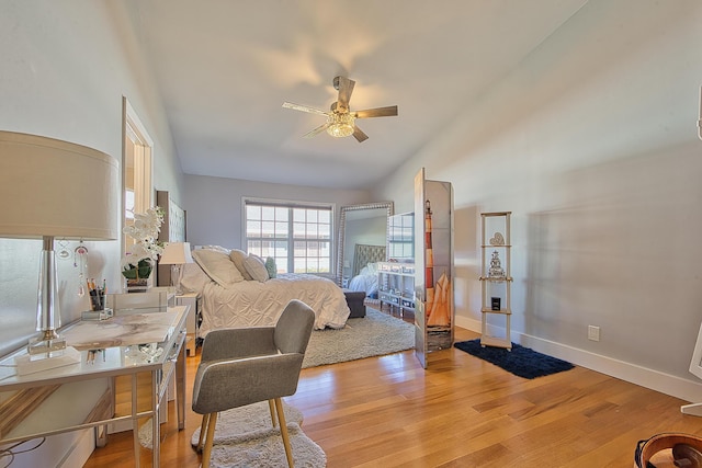 bedroom featuring light wood-type flooring, vaulted ceiling, and ceiling fan