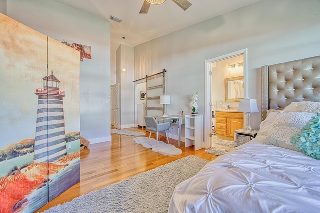 bedroom featuring connected bathroom, light hardwood / wood-style flooring, ceiling fan, and vaulted ceiling