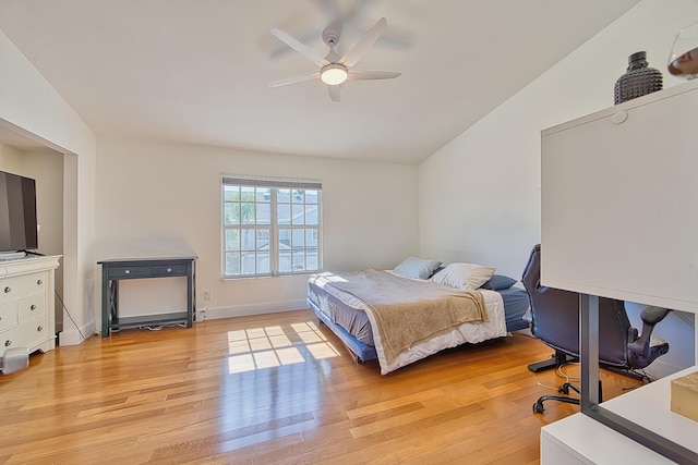 bedroom featuring ceiling fan, light hardwood / wood-style floors, and lofted ceiling