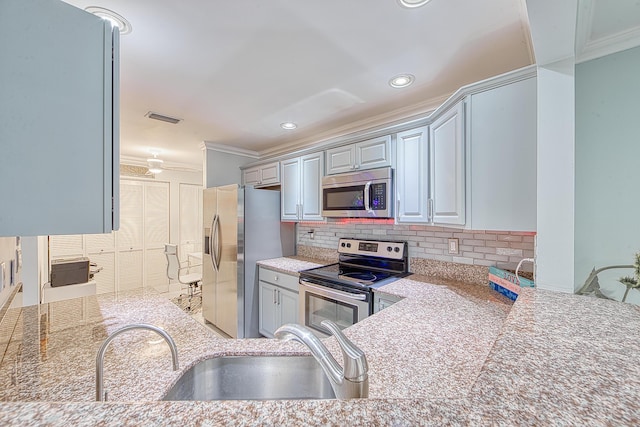 kitchen with sink, gray cabinets, ornamental molding, appliances with stainless steel finishes, and tasteful backsplash