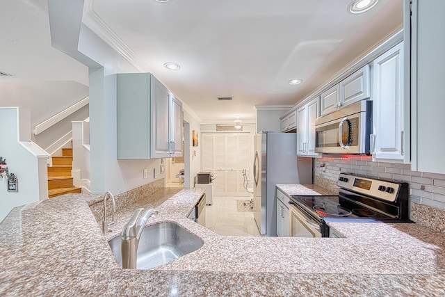 kitchen featuring decorative backsplash, sink, ornamental molding, and appliances with stainless steel finishes