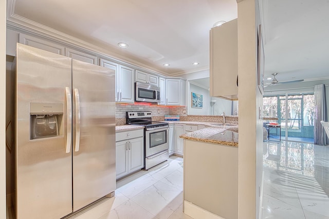 kitchen featuring sink, ceiling fan, gray cabinets, decorative backsplash, and appliances with stainless steel finishes