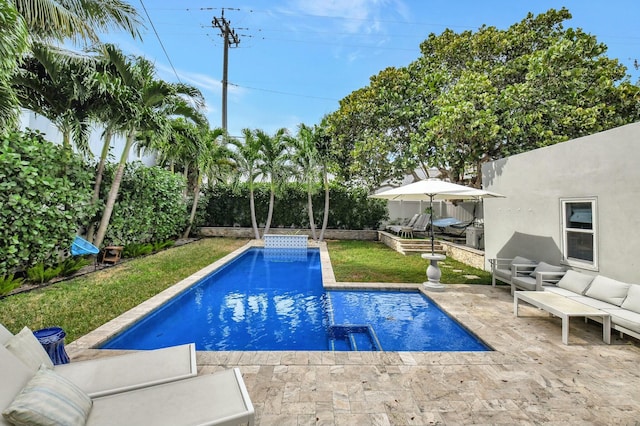 view of swimming pool featuring outdoor lounge area, a yard, and a patio