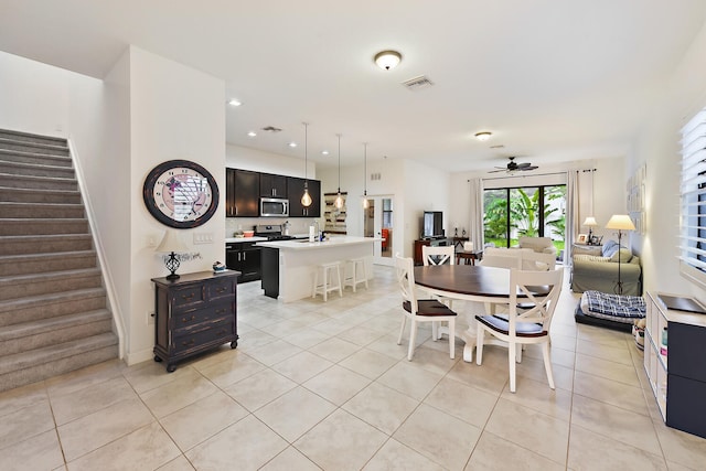 tiled dining area with ceiling fan and sink