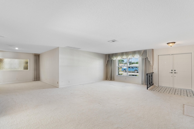 interior space with light colored carpet and a textured ceiling