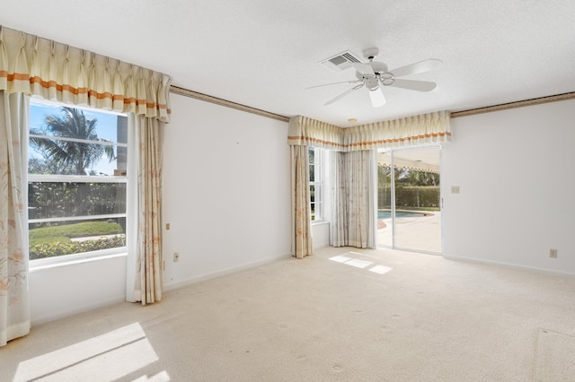 carpeted empty room with ceiling fan, a textured ceiling, and ornamental molding