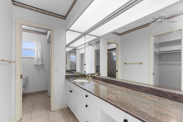 bathroom featuring toilet, vanity, ceiling fan, tile patterned floors, and crown molding