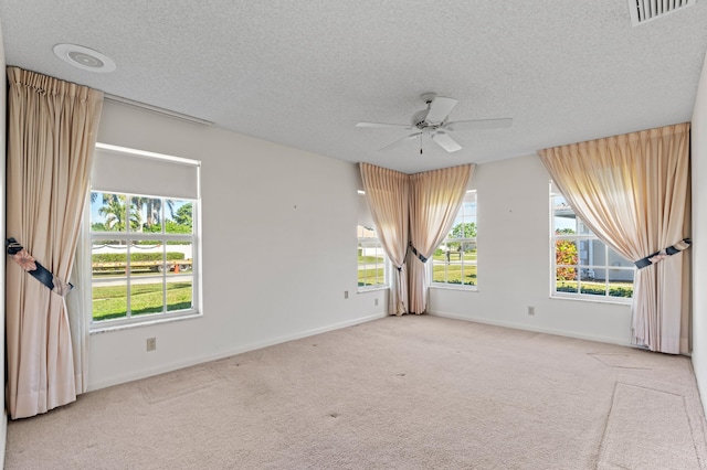 carpeted spare room with ceiling fan and a textured ceiling