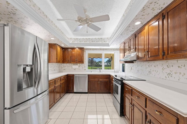 kitchen featuring stainless steel appliances, ornamental molding, a raised ceiling, ceiling fan, and light tile patterned floors