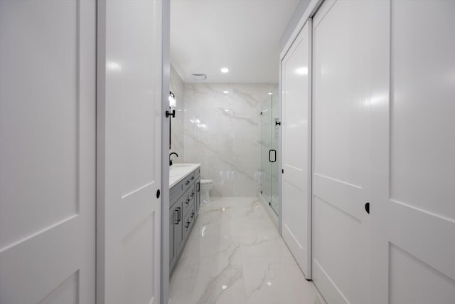 bathroom with vanity, toilet, walk in shower, and tile walls